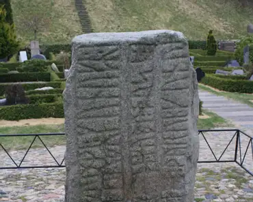 06 The oldest is the smallest stone, erected by king Gorm in memory of his wife Thyra. The text says "Gorm king made this memorial stone for Thyra, his wife,...